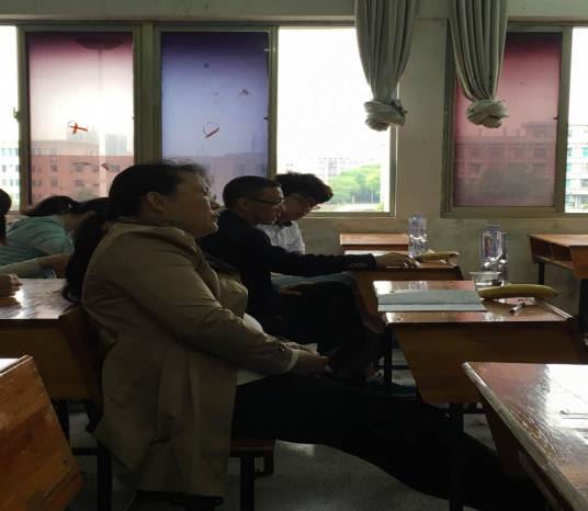 廖小莲、罗志军两位老师在听学生讲课