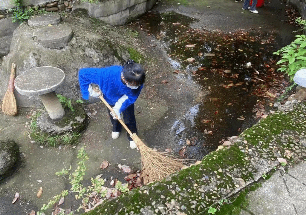 同学们打扫水池中的树叶
